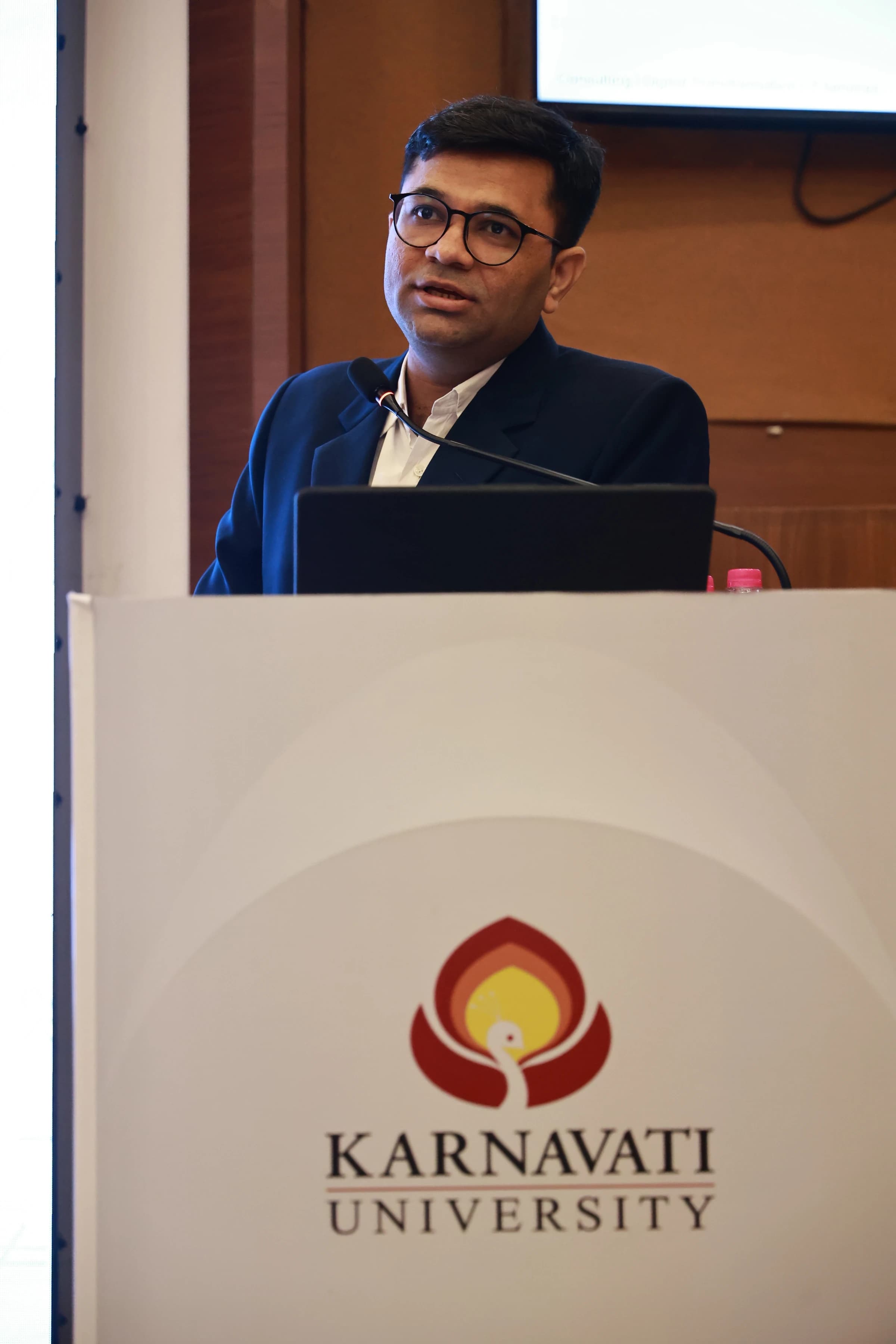 Madhav Anadkat speaking from Karnavati University podium